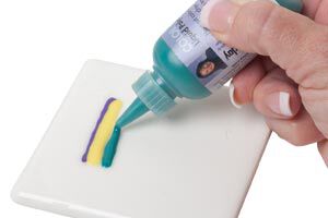 Green polyclay being squeezed onto white clay